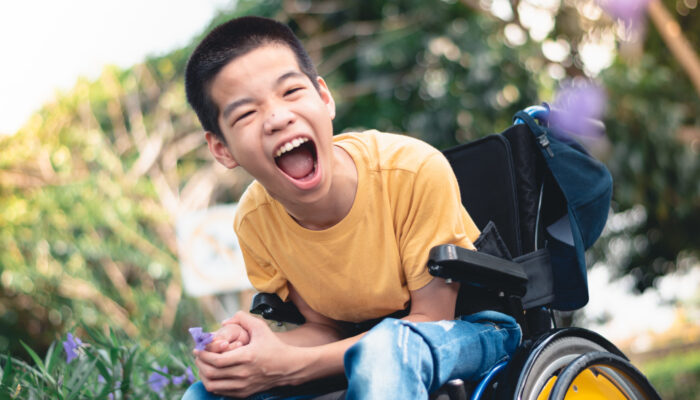 Disabled child on wheelchair is playing, learning and exercise in the outdoor city park like other people,Lifestyle of special child,Life in the education age of children,Happy disability kid concept.
